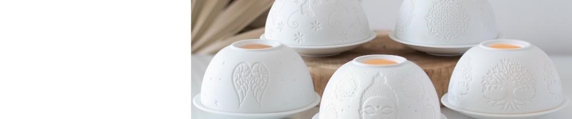 Matte white ceramic oil burners and wax melt warmers with spiritual designs including mandalas, angel wings and tree of life motifs. Elegant wholesale home fragrance accessories for calm and relaxing interiors. No minimum order, ships worldwide.