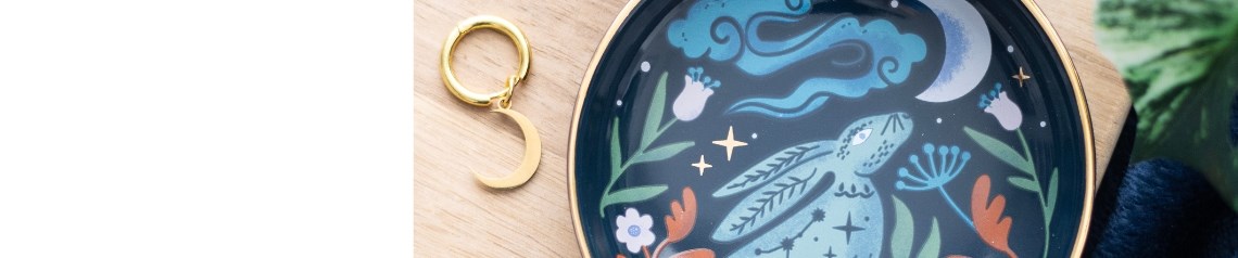 Midnight Hare wholesale gift and homeware range featuring celestial hare illustrations symbolising growth and new beginnings. Includes candles, cushions, incense, mugs, notebooks, jewellery, and decor in deep blue and gold tones. A magical, meaningful collection ideal for winter gifting, spring refreshes, Easter displays, and spiritual retailers seeking products that blend beauty with symbolism.